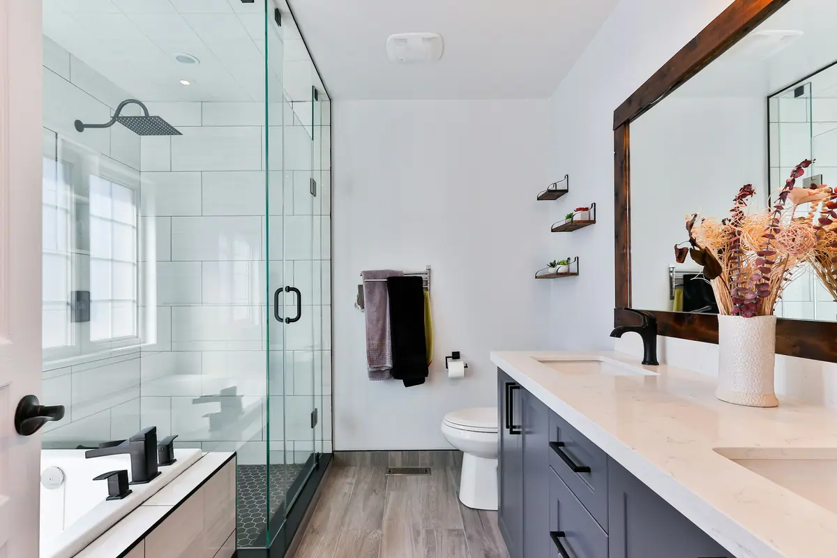 Baño moderno con mampara de vidrio templado y griferías cromadas