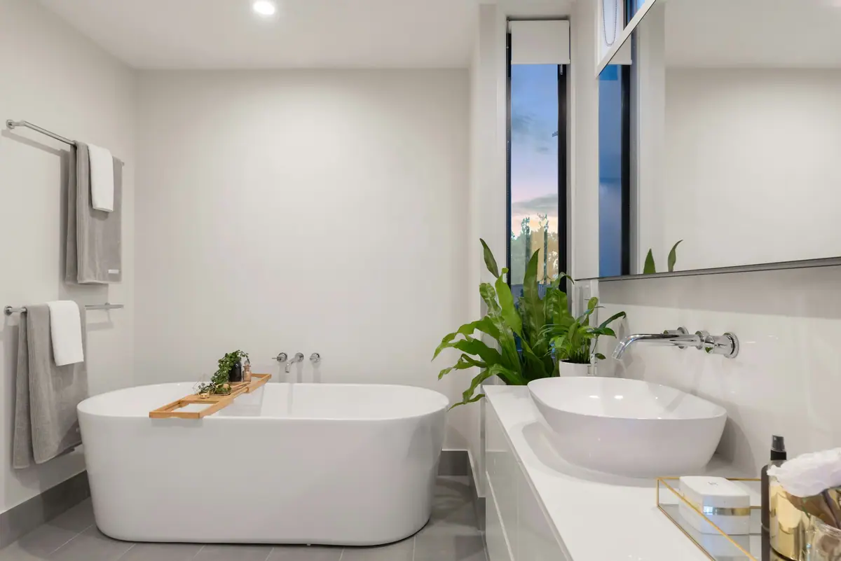 Baño luminoso y minimalista con bañera exenta, doble bacha y plantas